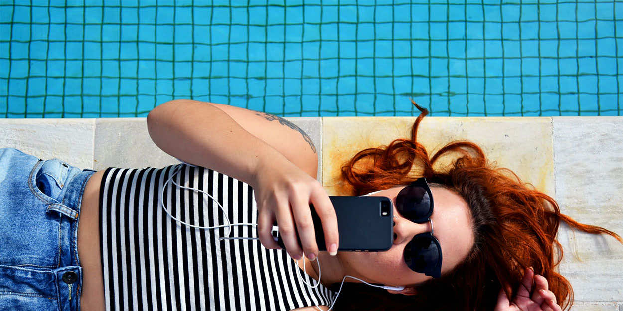 Girl by pool taking a picture