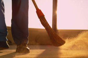 man sweeping dirt